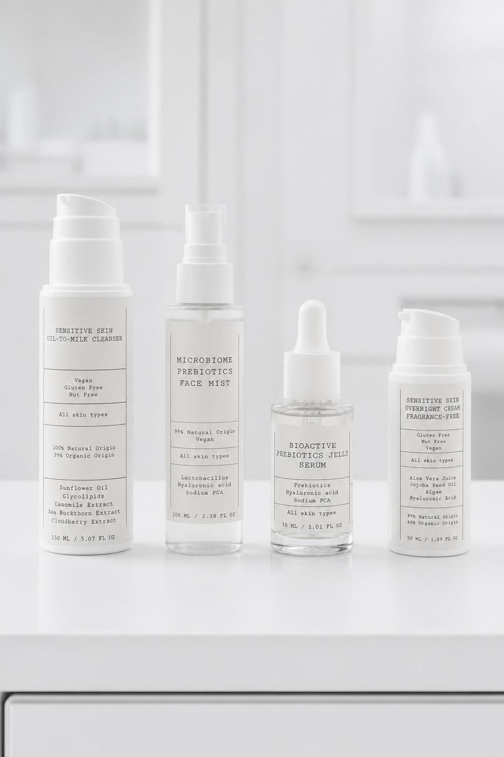 D.E.N. The Recovery Kit: cleanser, mist, serum and cream bottles on a white bathroom shelf